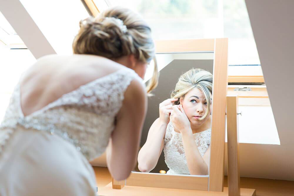 Bridal Prep - ©LouiseMallanPhotograhy - Bride getting ready by a window in natural light 