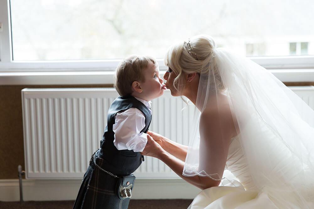Bride kissing her son before her wedding ©Louisemallanphotography